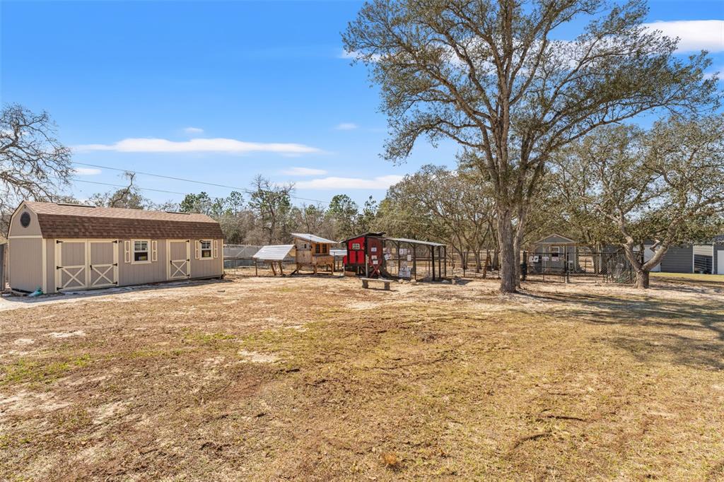 12277 Eskimo Curlew Road Weeki Wachee, FL 34614 - Photo 71 of 84 a view of a large house with a big yard and large trees