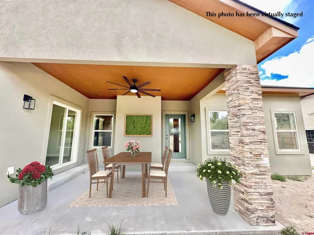 a view of a patio with a table and chairs and potted plants