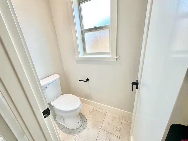a white toilet sitting next to a window