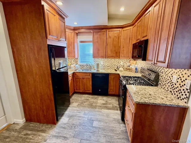a kitchen with stainless steel appliances granite countertop wooden cabinets a sink and a counter space