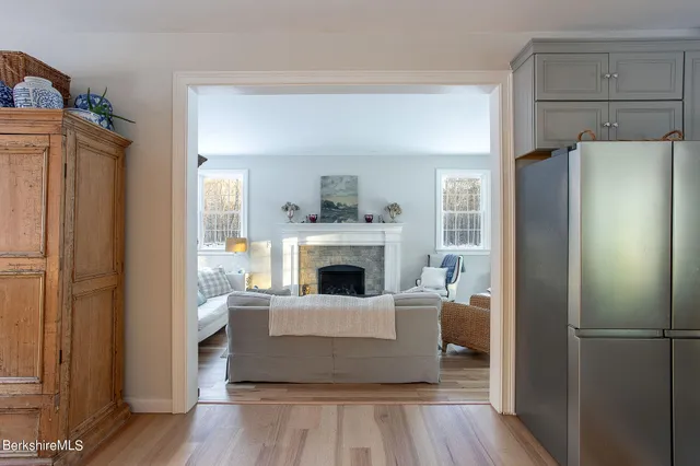 a living room with a fireplace and a refrigerator