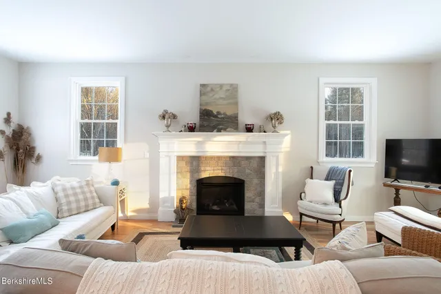 a living room with furniture a flat screen tv and a fireplace