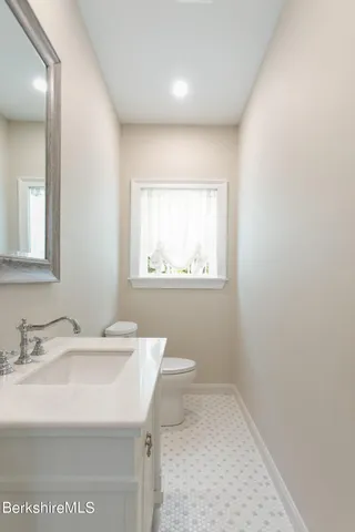 a bathroom with a sink a toilet and a window