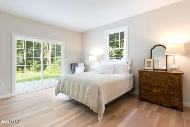 a bedroom with a bed and a dresser next to a window