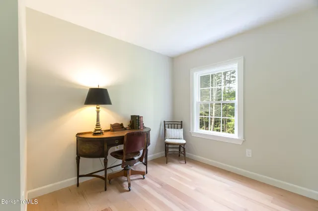 a view of a workspace with furniture and a window