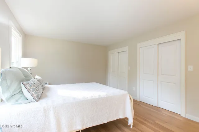 a bedroom with a bed and a wooden floor