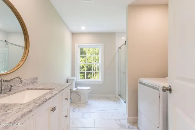 a bathroom with a granite countertop sink toilet and a mirror