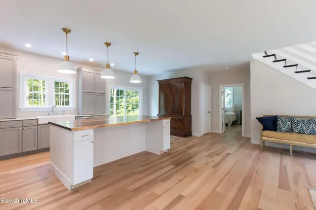 a large kitchen with kitchen island a sink stainless steel appliances and cabinets