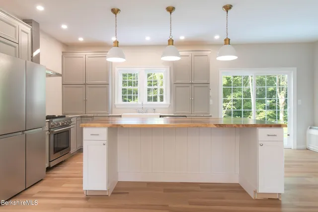 a kitchen with granite countertop a stove a sink and a refrigerator