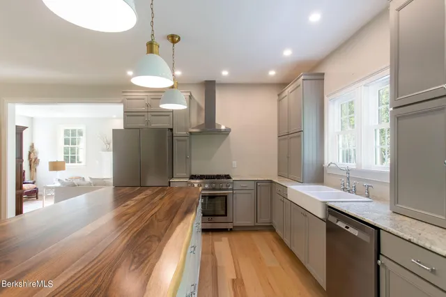 a kitchen with stainless steel appliances granite countertop a sink a stove and a refrigerator