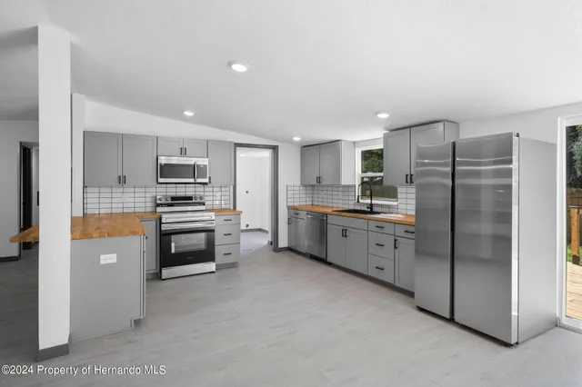 a kitchen with stainless steel appliances a refrigerator sink and cabinets