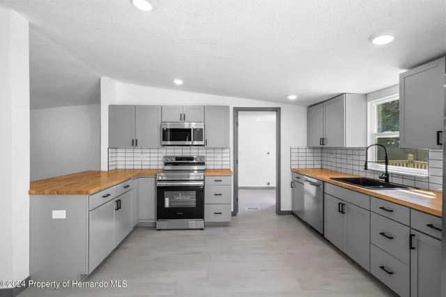 a large kitchen with cabinets and stainless steel appliances