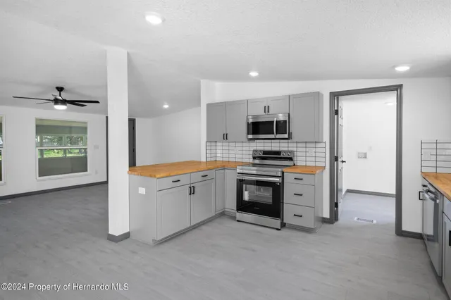 a kitchen with stainless steel appliances a stove sink and microwave