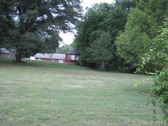 384 Pitts School Road Northwest Concord, NC 28027 - Photo 2 of 4 a backyard of a house with lots of green space and trees