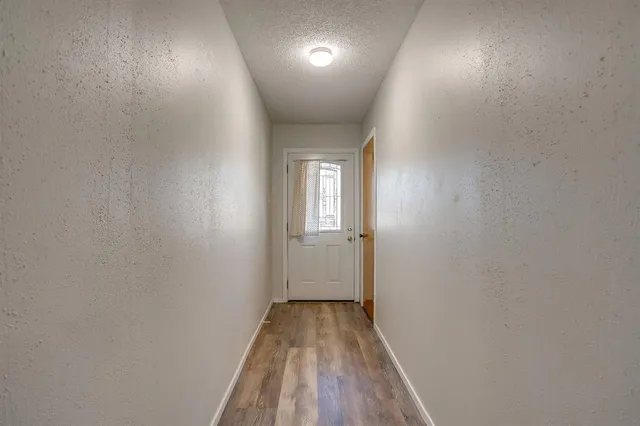 a view of a hallway with wooden floor