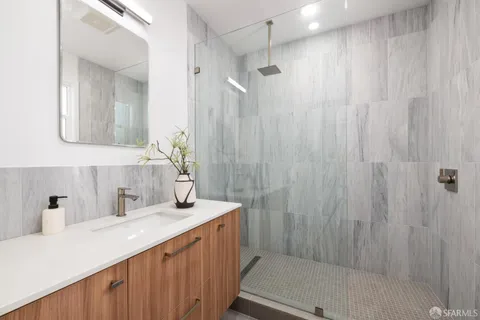 a bathroom with a sink a mirror and a shower