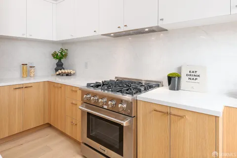 a kitchen with a stove and a white cabinets