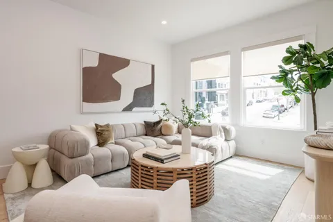 a living room with furniture and a potted plant
