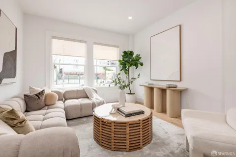 a living room with furniture a window and a potted plant