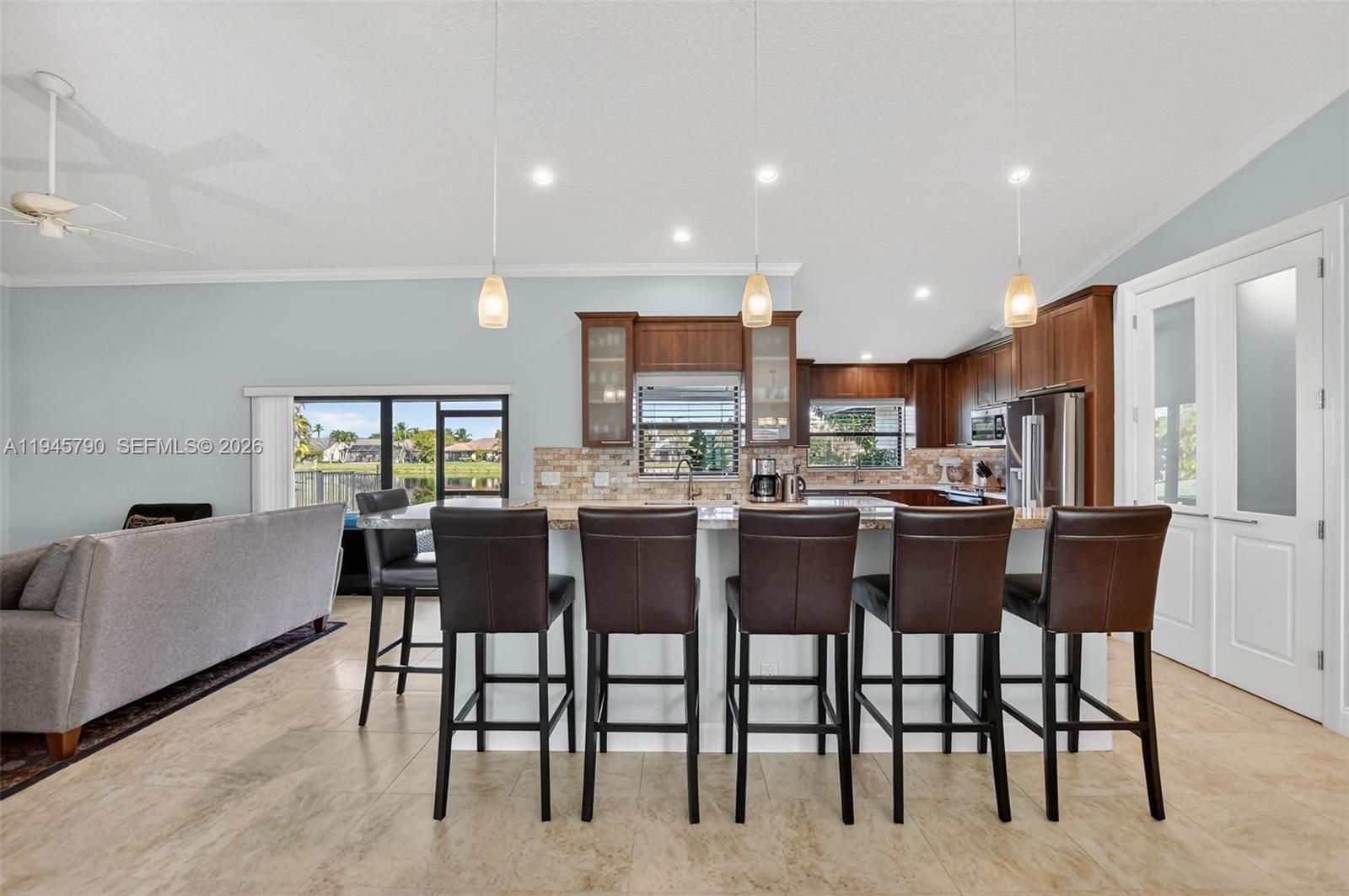 9943 Majorca Place Boca Raton, FL 33434 - Photo 12 of 48 a kitchen with a dining table chairs and white appliances