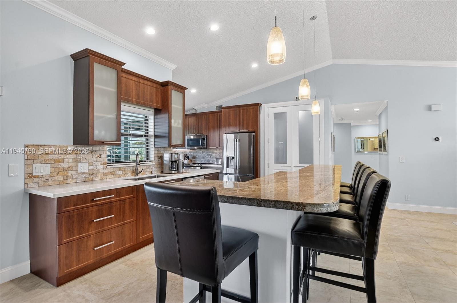 9943 Majorca Place Boca Raton, FL 33434 - Photo 13 of 48 a kitchen with a dining table chairs and cabinets