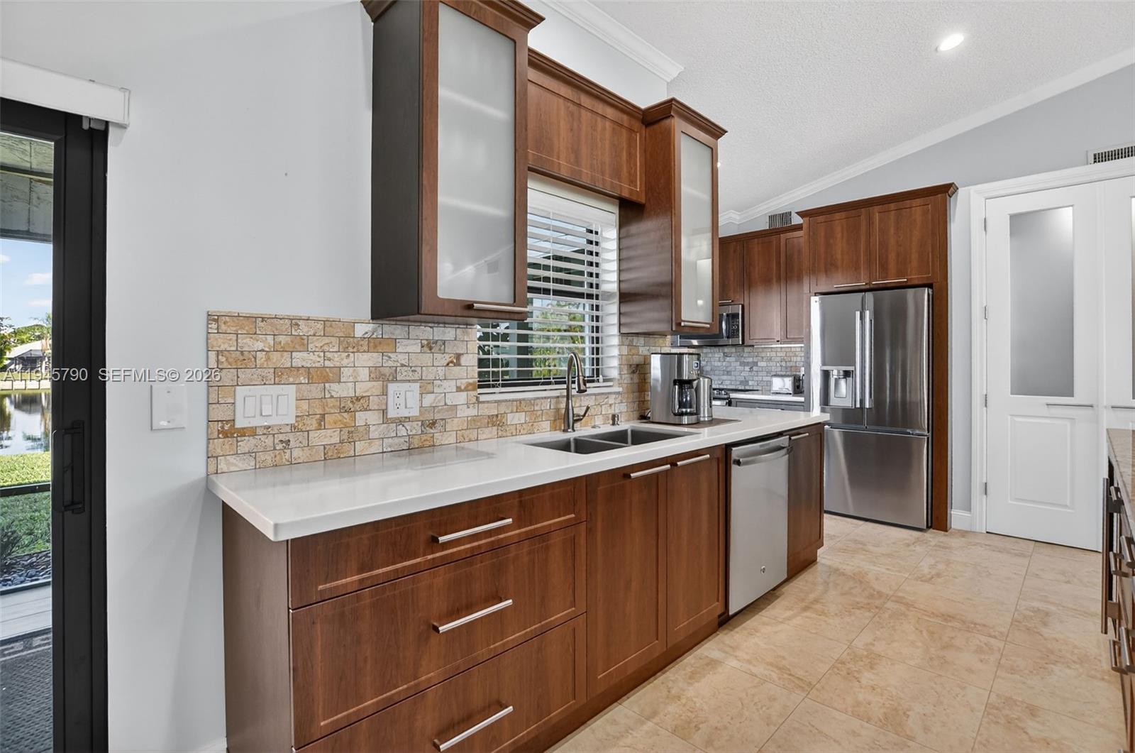 9943 Majorca Place Boca Raton, FL 33434 - Photo 18 of 48 a kitchen with stainless steel appliances granite countertop a sink stove and refrigerator