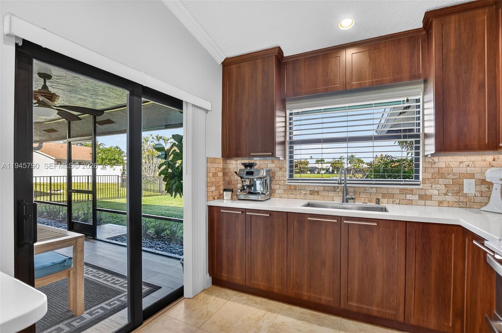 9943 Majorca Place Boca Raton, FL 33434 - Photo 20 of 48 a kitchen with stainless steel appliances wooden cabinets a refrigerator and a sink