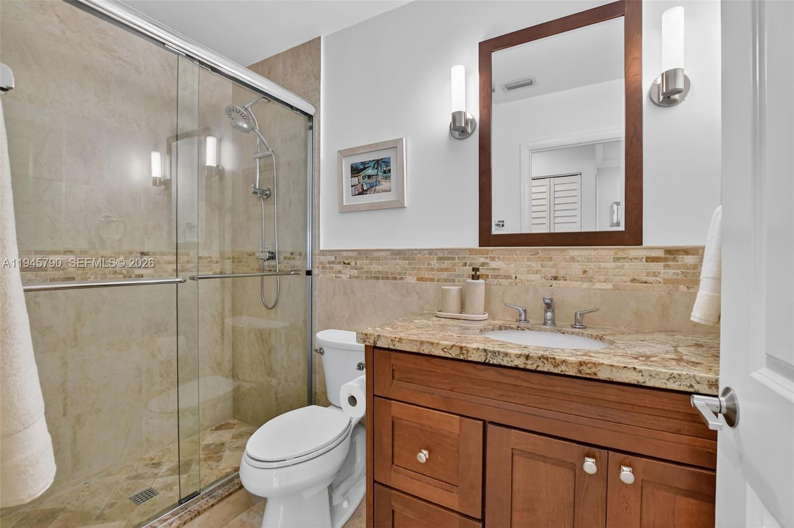 9943 Majorca Place Boca Raton, FL 33434 - Photo 36 of 48 a bathroom with a granite countertop sink toilet and shower