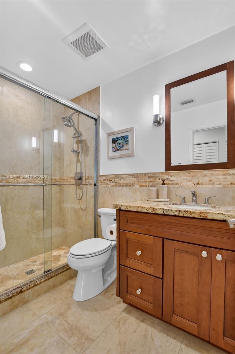 9943 Majorca Place Boca Raton, FL 33434 - Photo 38 of 48 a bathroom with a granite countertop sink toilet mirror and shower