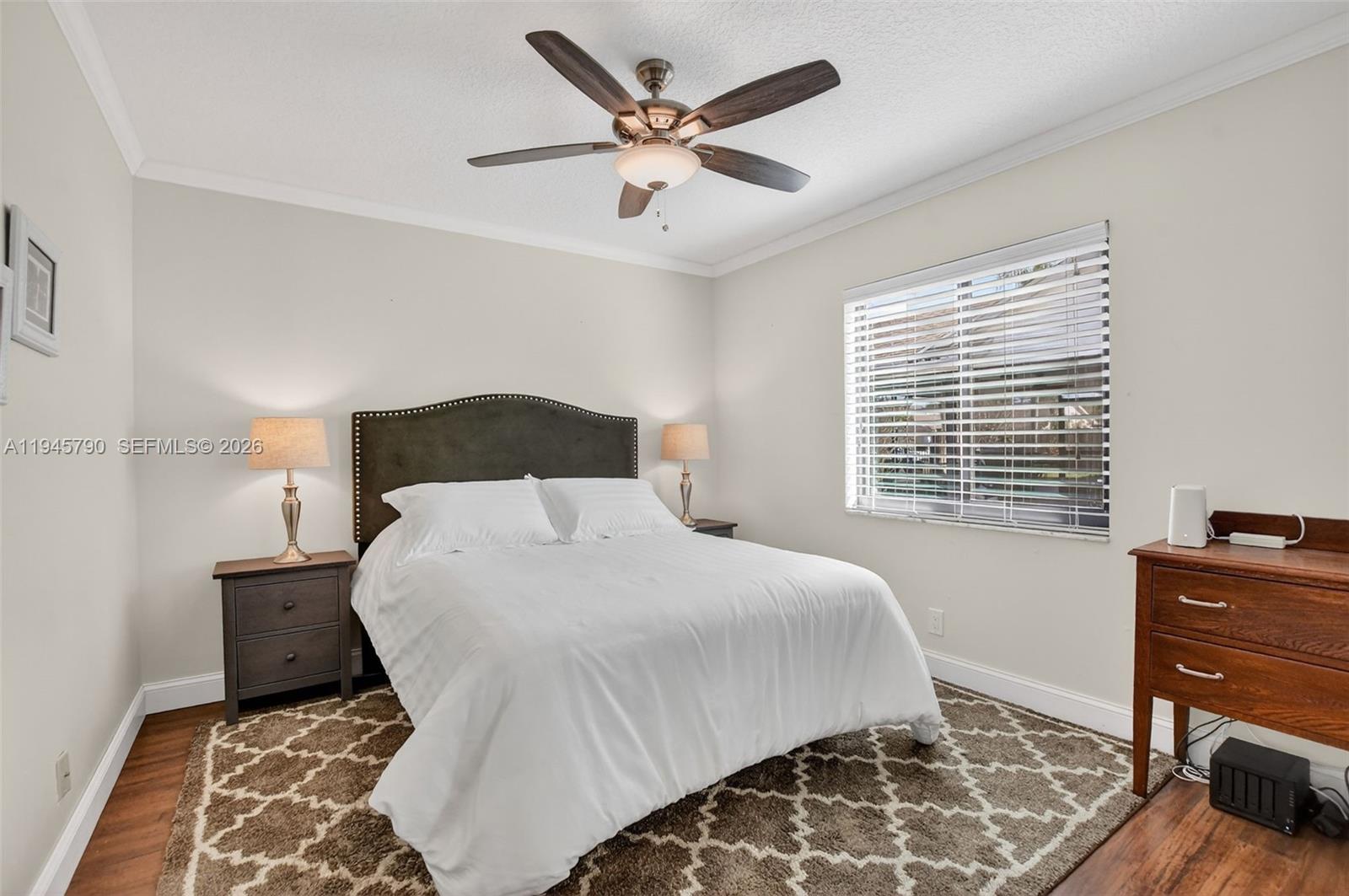 9943 Majorca Place Boca Raton, FL 33434 - Photo 39 of 48 a bedroom with a bed and dresser with wooden floor