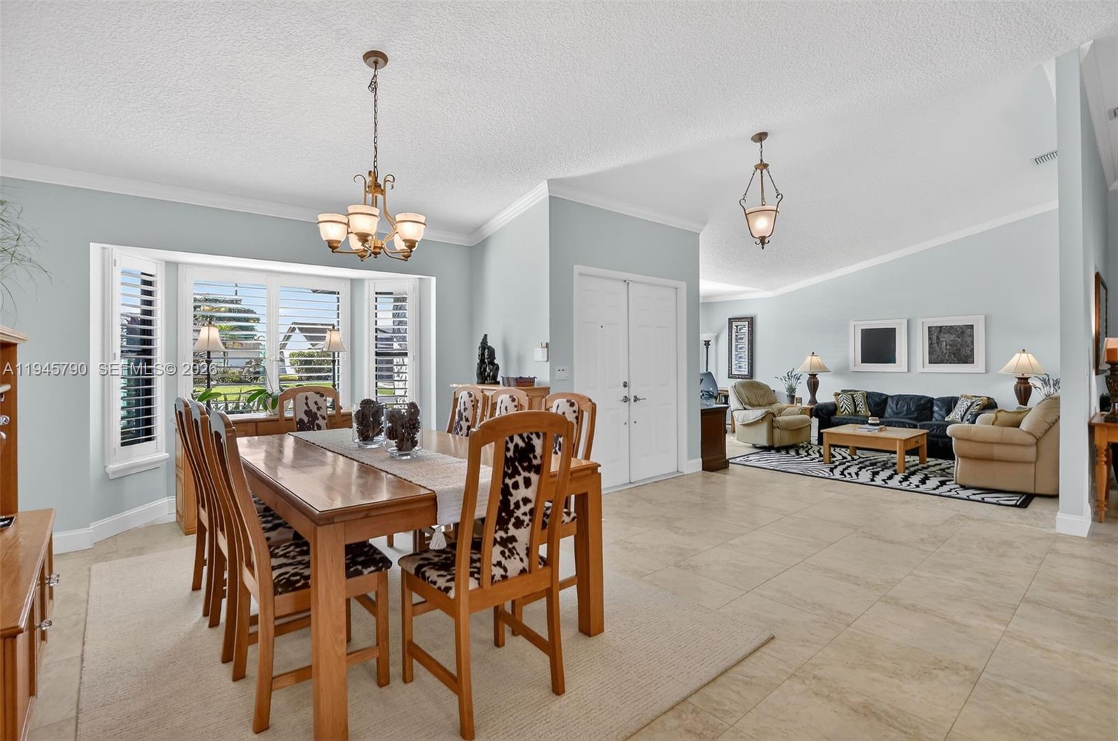 9943 Majorca Place Boca Raton, FL 33434 - Photo 8 of 48 a dining room with furniture a chandelier and a rug
