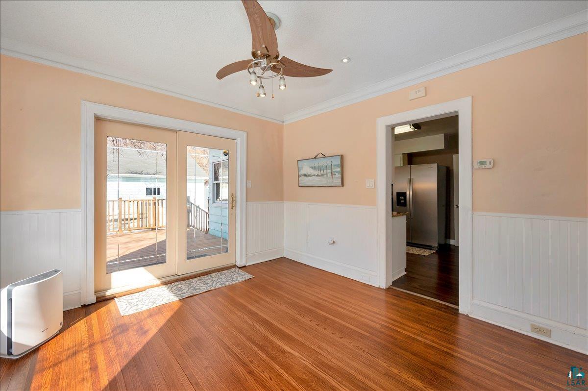 4345 West 8th Street Duluth, MN 55807 - Photo 11 of 31 Unfurnished room with ceiling fan, wainscoting, wood finished floors, and crown molding