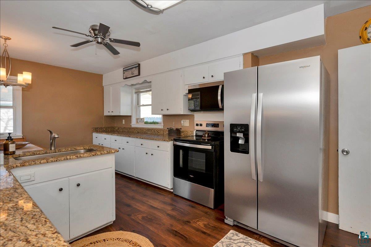 4345 West 8th Street Duluth, MN 55807 - Photo 15 of 31 Kitchen featuring stainless steel appliances, white cabinets, dark wood-style floors, and a ceiling fan