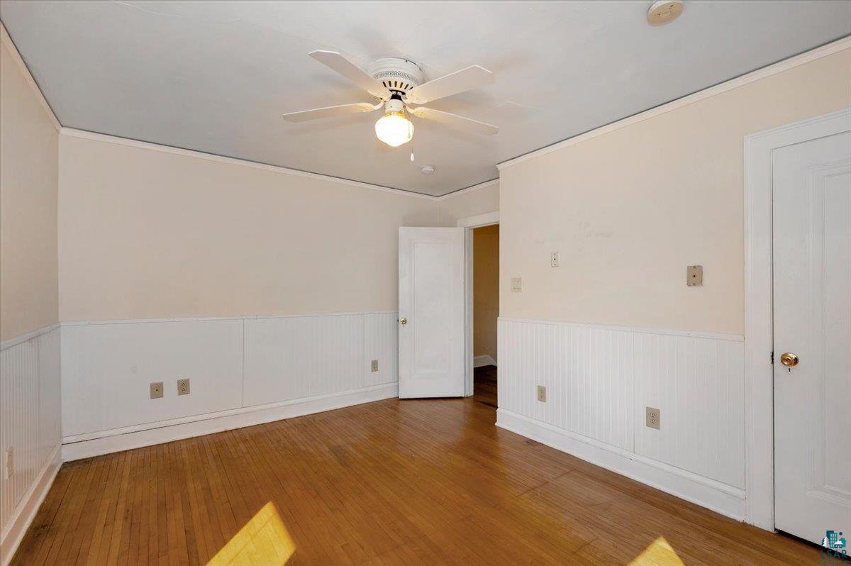 4345 West 8th Street Duluth, MN 55807 - Photo 24 of 31 Spare room featuring hardwood / wood-style floors, ceiling fan, and a wainscoted wall
