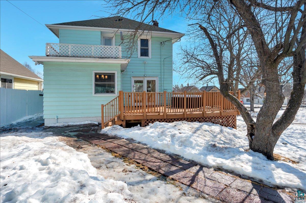 4345 West 8th Street Duluth, MN 55807 - Photo 4 of 31 Snow covered house with a wooden deck, a chimney, and a balcony