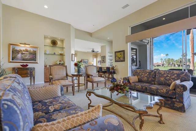 a living room with furniture a bookshelf and a window