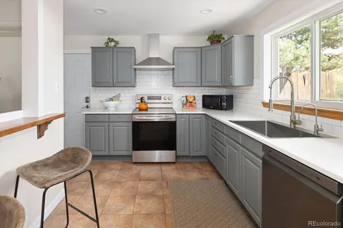 a kitchen with stainless steel appliances granite countertop a sink window and cabinets
