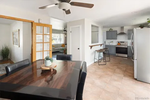 a living room with stainless steel appliances furniture a rug and a large window