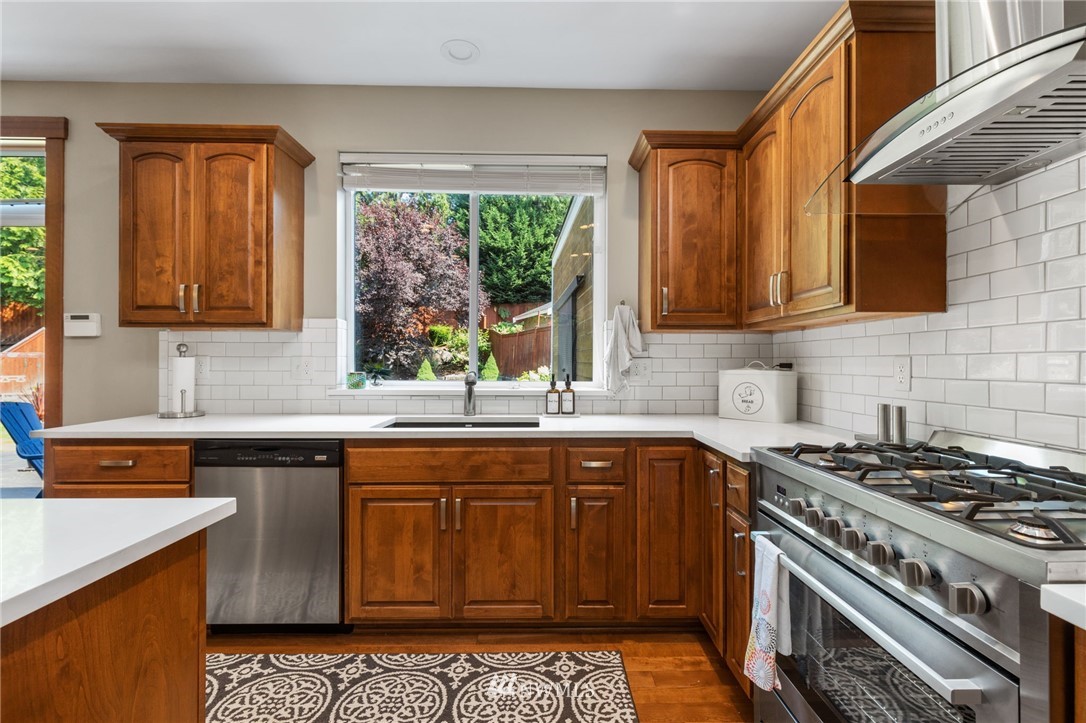 3113 223rd Street Southeast Bothell, WA 98021 - Photo 12 of 40 a kitchen with a sink stove top oven and cabinets