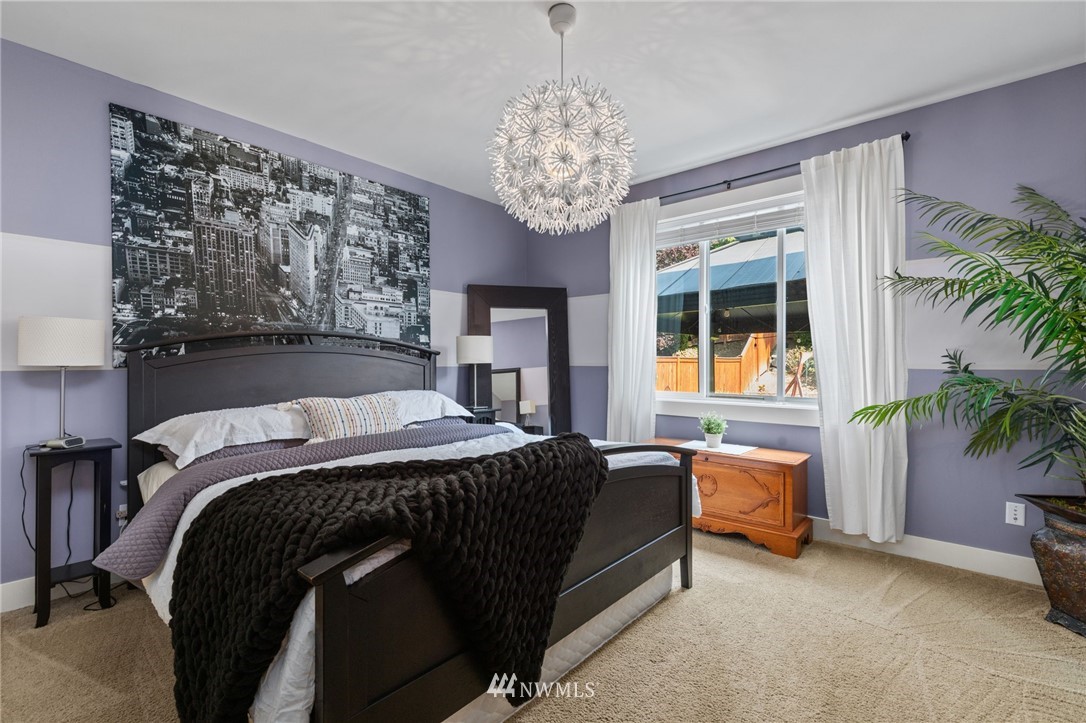 3113 223rd Street Southeast Bothell, WA 98021 - Photo 17 of 40 a bed sitting in a bedroom next to a window and a chair