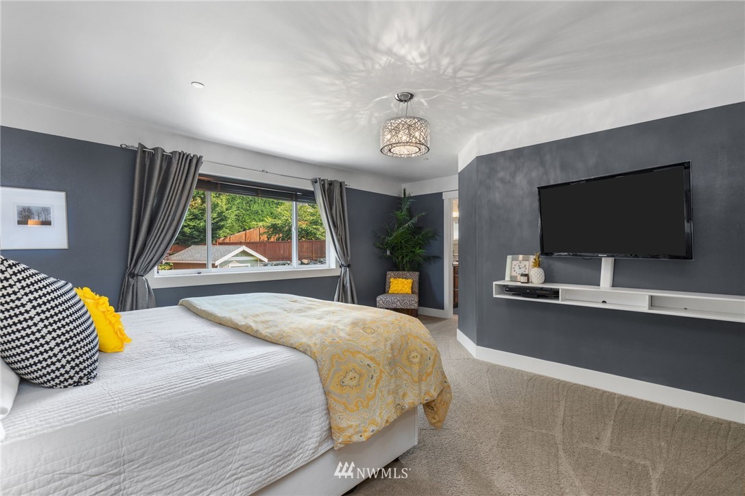 3113 223rd Street Southeast Bothell, WA 98021 - Photo 23 of 40 a bedroom with a bed and a flat screen tv