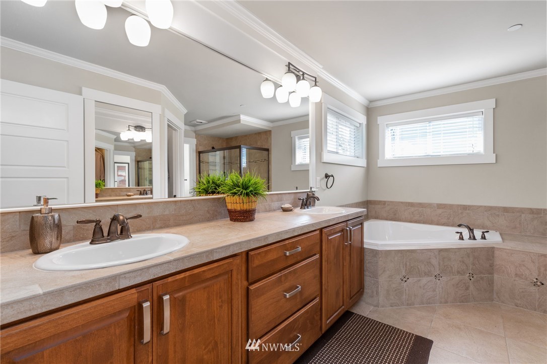 3113 223rd Street Southeast Bothell, WA 98021 - Photo 26 of 40 a bathroom with a granite countertop sink a large mirror and a bathtub