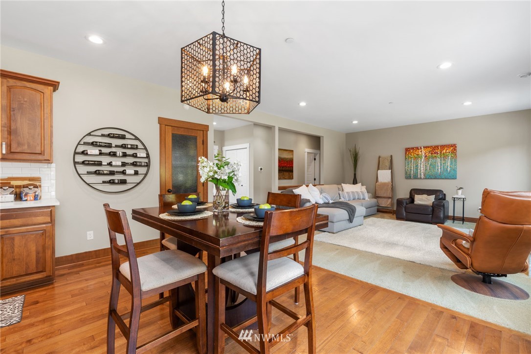 3113 223rd Street Southeast Bothell, WA 98021 - Photo 8 of 40 a view of a dining room with furniture a chandelier and wooden floor