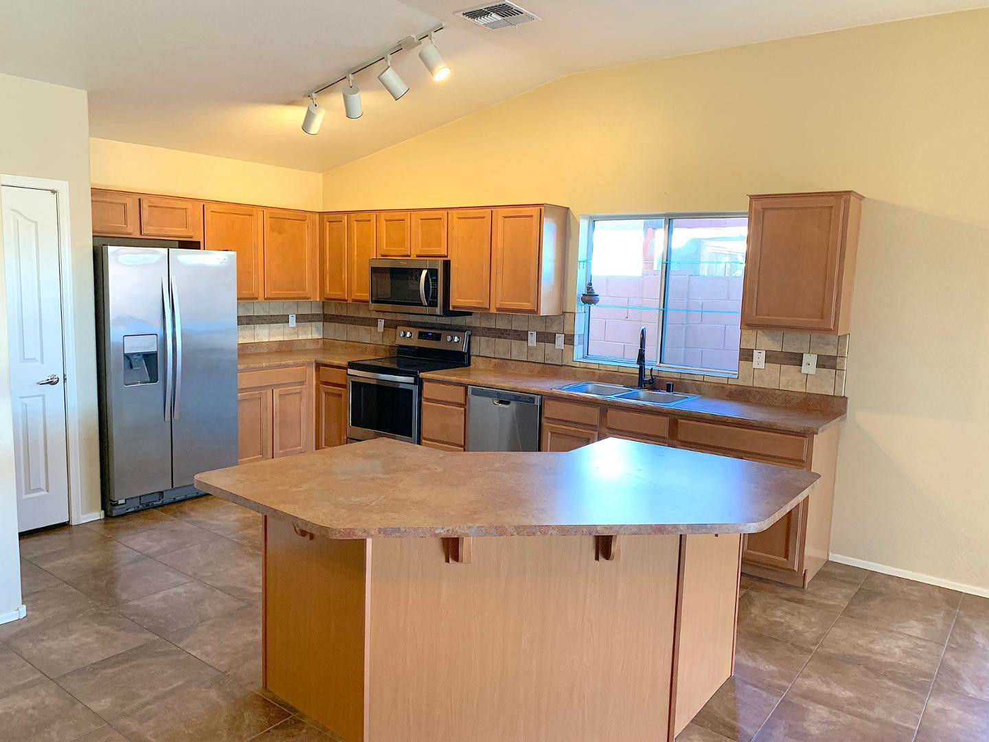 4132 East Chambers Street Phoenix, AZ 85040 - Photo 2 of 28 a kitchen with stainless steel appliances granite countertop a sink refrigerator and microwave