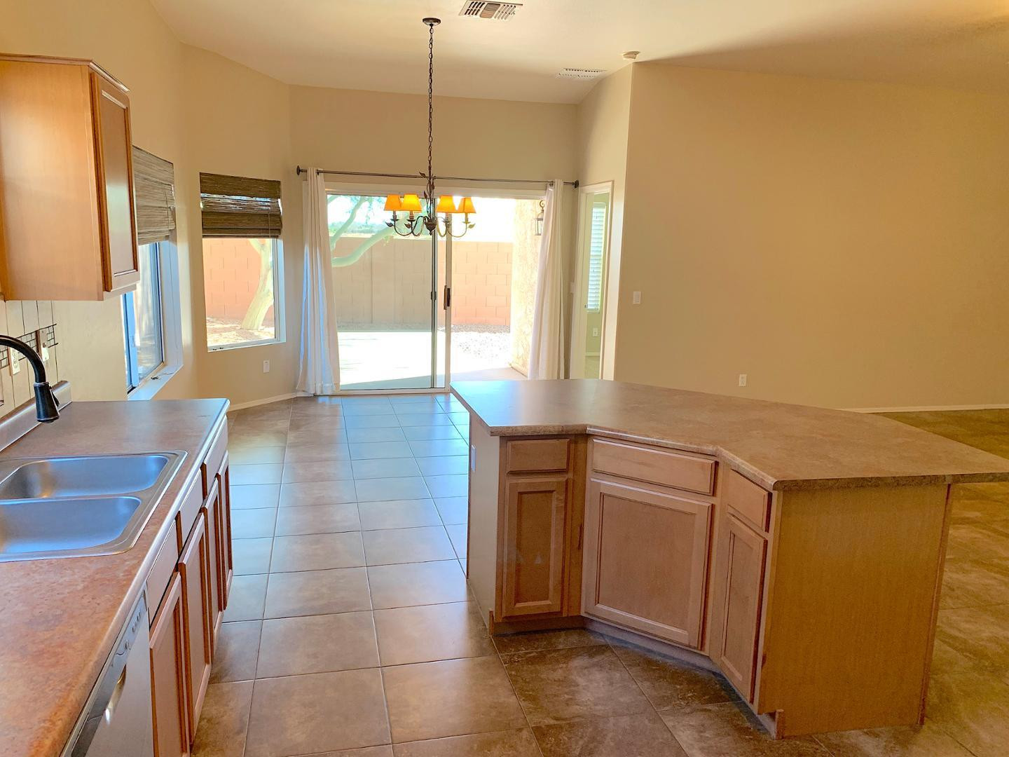 4132 East Chambers Street Phoenix, AZ 85040 - Photo 4 of 28 a kitchen with kitchen island a counter top space appliances and a large window