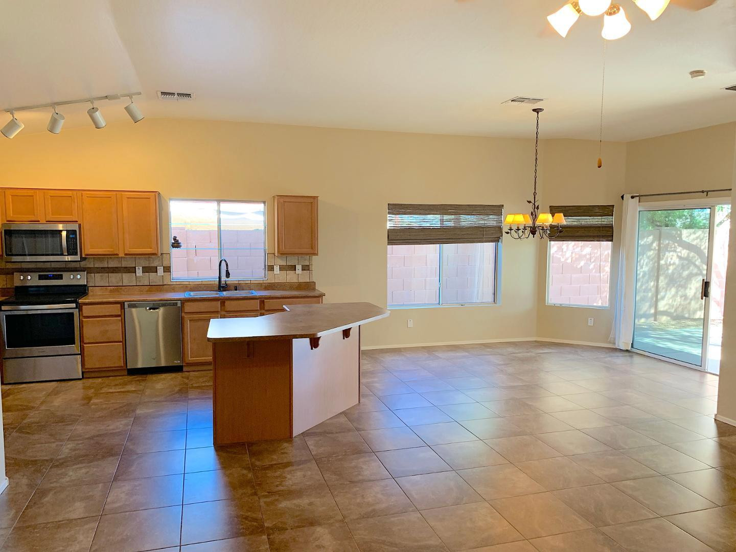 4132 East Chambers Street Phoenix, AZ 85040 - Photo 7 of 28 a kitchen with kitchen island granite countertop a sink counter top space appliances and cabinets