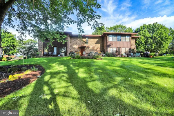 a view of a house with a big yard and large trees