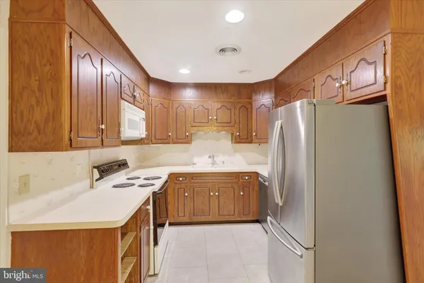 a kitchen with stainless steel appliances granite countertop a refrigerator and a sink