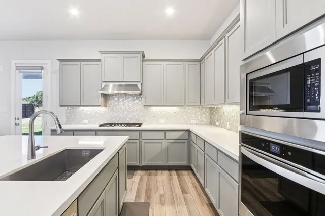 a kitchen with a sink stove and microwave