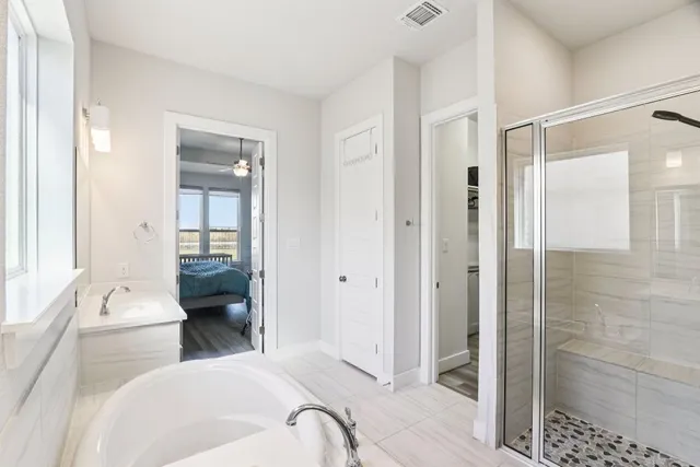 a en suite bathroom with a bathtub double sink and mirror